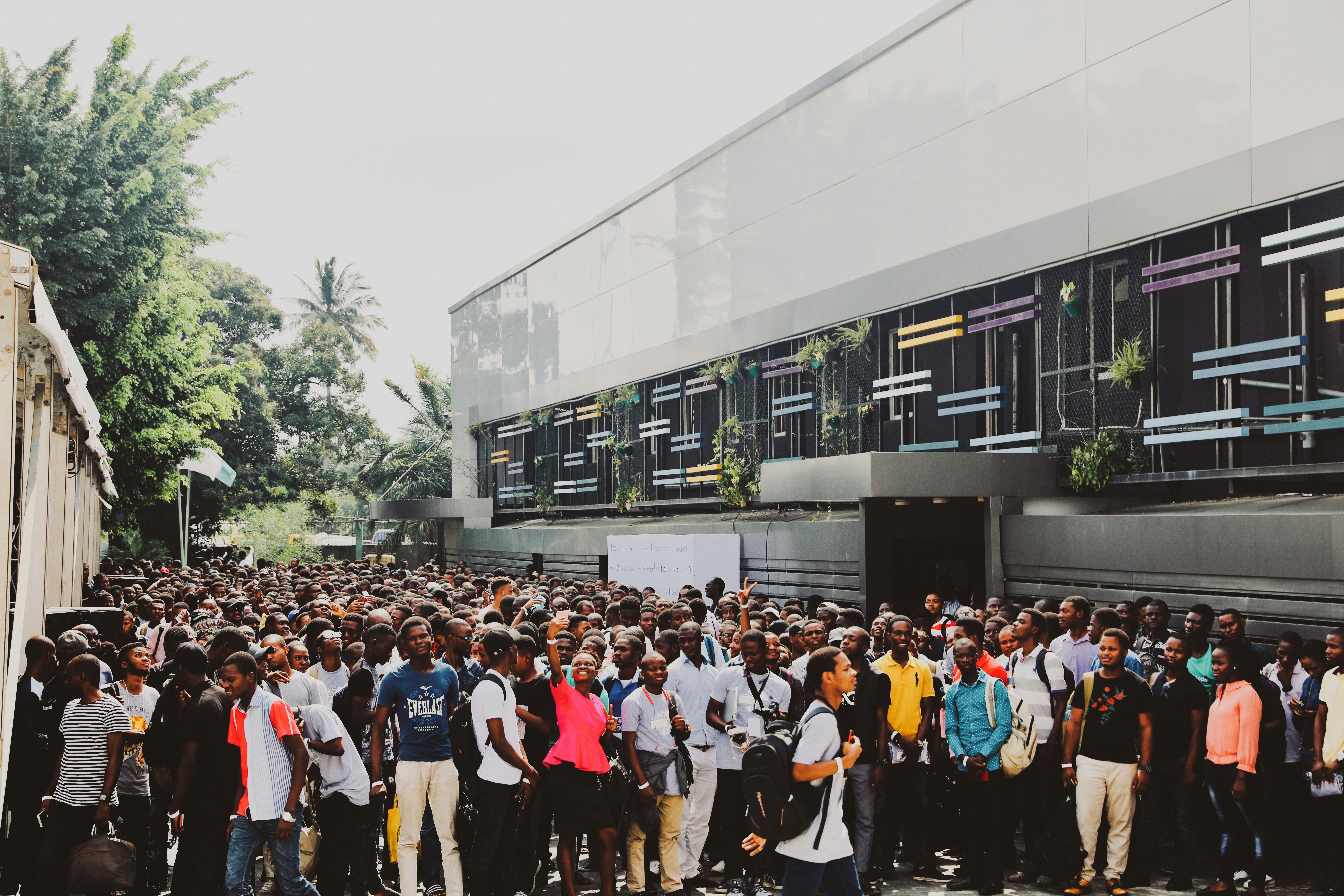 Large community gathering with diverse crowd of young people in urban setting